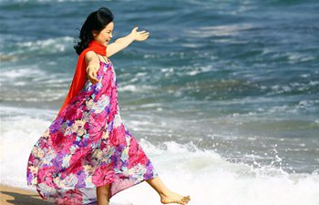 Tourists have fun by seaside in Sanya, S China