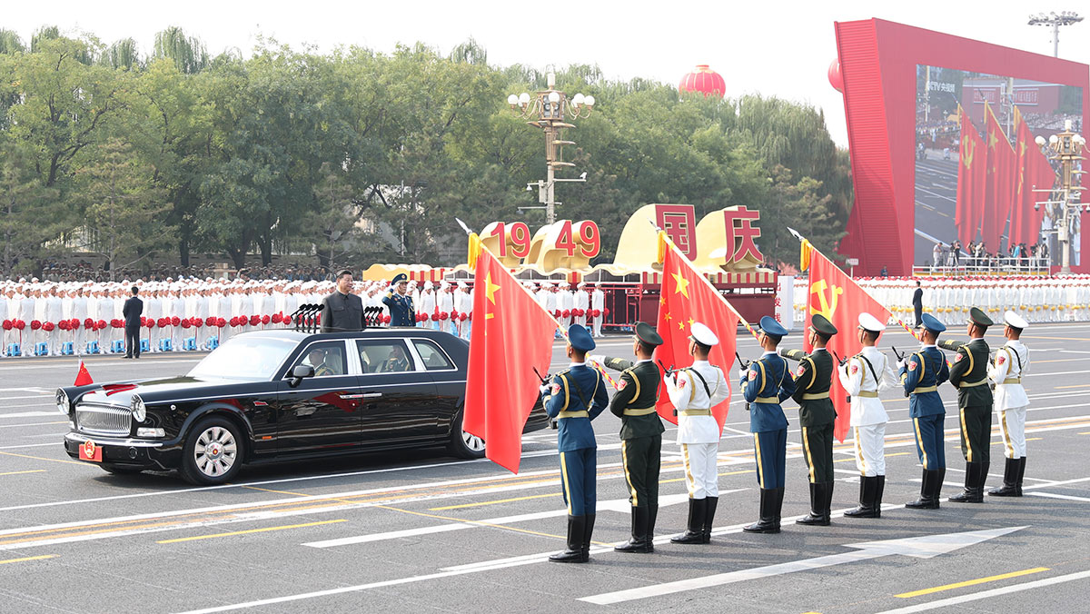 習(xí)近平驅(qū)車行進(jìn)至黨旗、國旗、軍旗前，向旗幟行注目禮